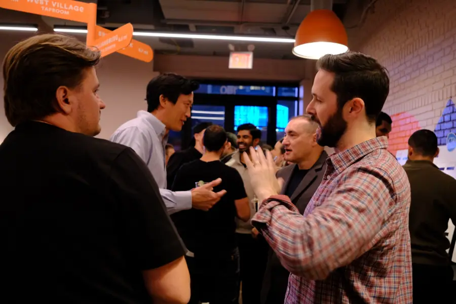 Attendees talking at the bar