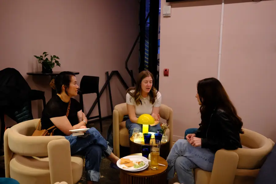 Attendees chatting in the lounge armchairs