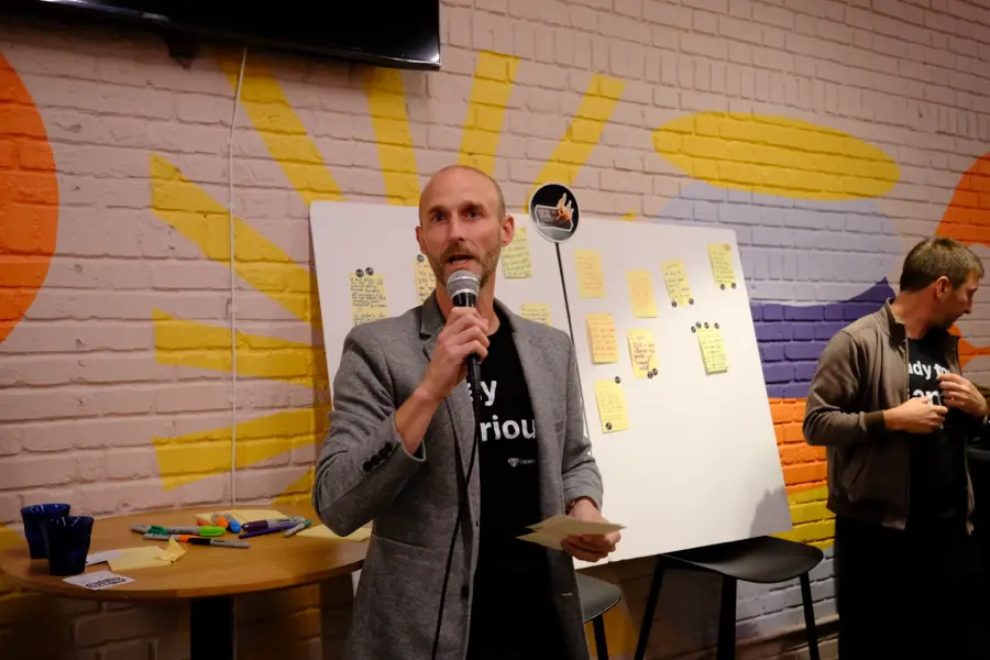 Sylvain Gauchet on the mic in front of the Screw-Ups board